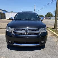 The same black Dodge Durango from the front with the bumper back on, parked on a lot