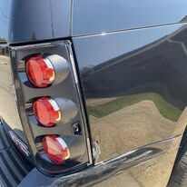 The same black GMC rear quarter with a smooth, glossy panel beside a round-lens tail light